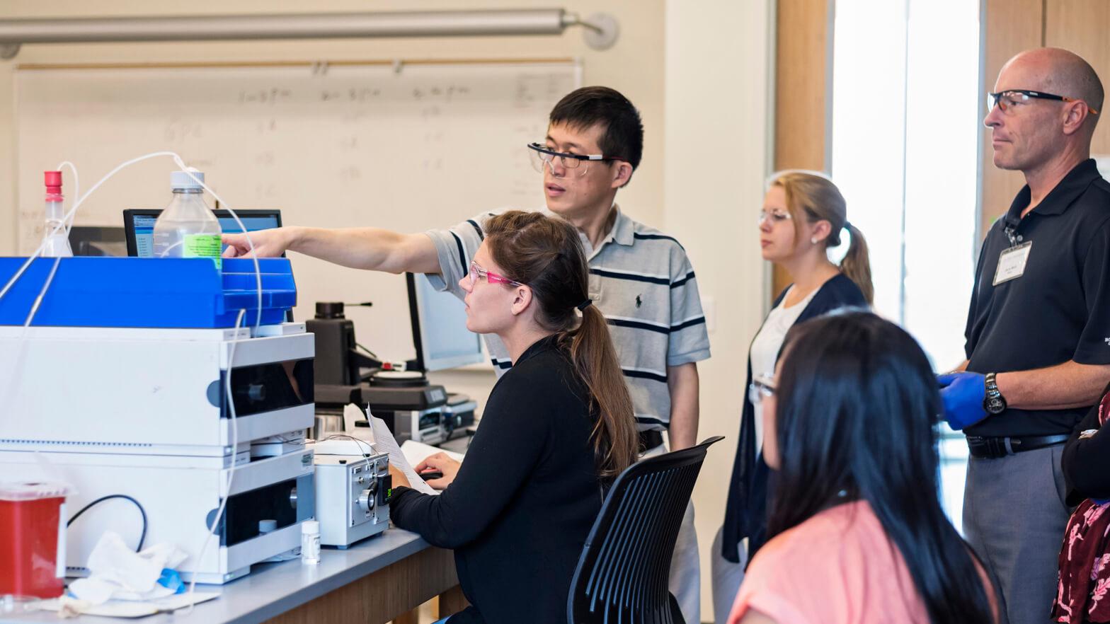 Students working together in a materials science lab analyzing equipment results.