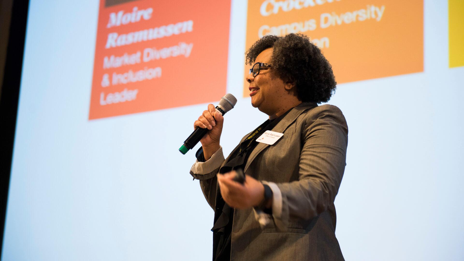 Speaker presents on diversity and inclusion while holding a microphone during a campus leadership event.